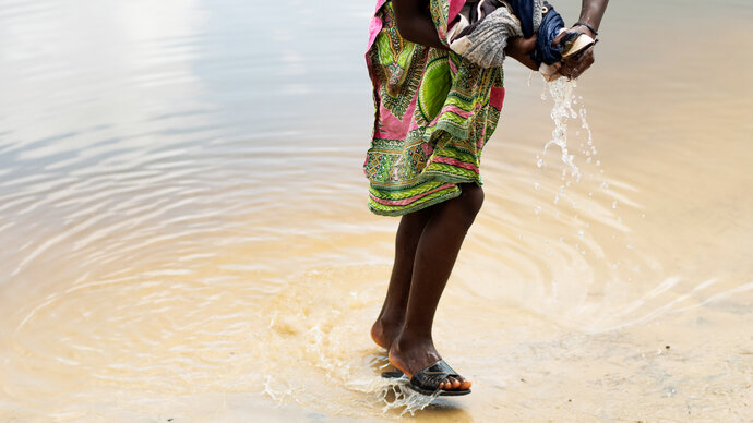 A young girl washes her clothes in a swamp between Soubré and Okrouyo in Côte d'Ivoire.